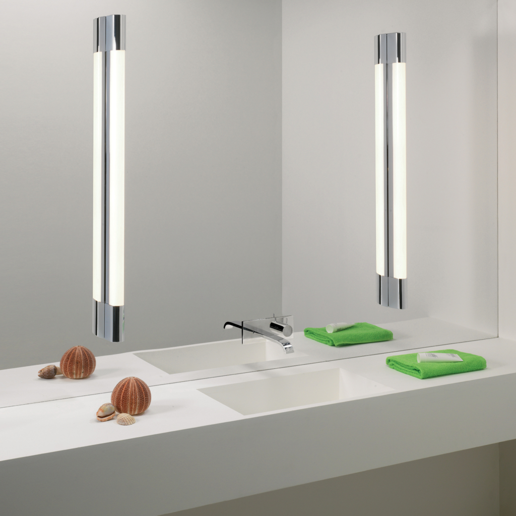 Palermo 900 LED vägglampa sittandes på vardera sida om en rektangulär spegel i ett badrum. Nedanför finns ett tvättställ och väggblandare.
