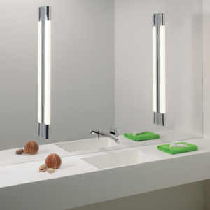 Palermo 900 LED vägglampa sittandes på vardera sida om en rektangulär spegel i ett badrum. Nedanför finns ett tvättställ och väggblandare.
