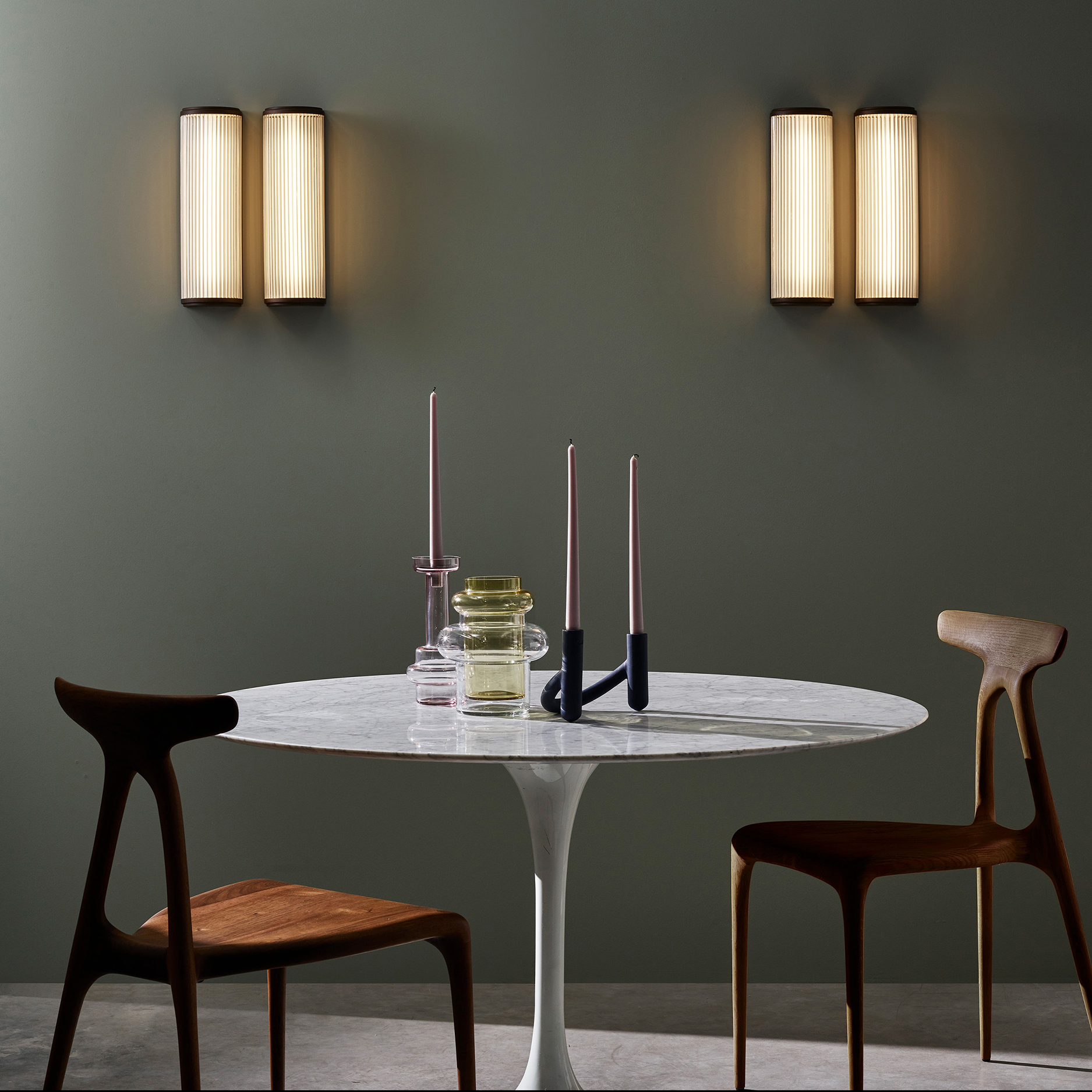 Versailles 400 Phase Dimmable vägglampa på en vägg i ett matrum med bord och fyra stolar.