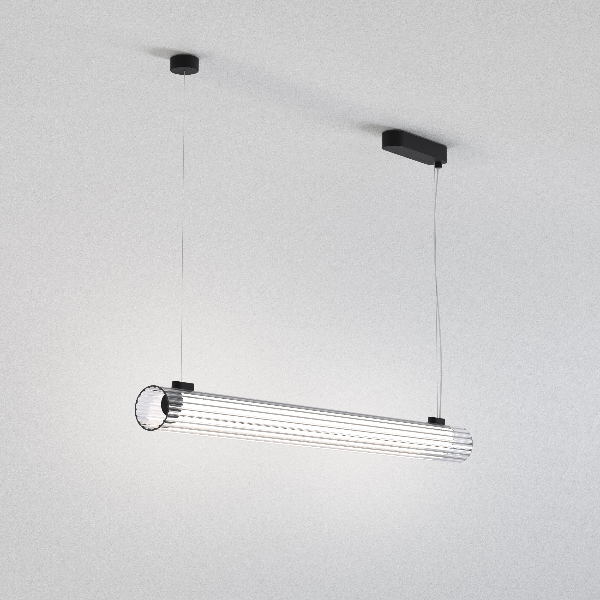 io Pendant 1000 taklampa, är en cylinderformad lampa som hänger från taket i två stållinor.