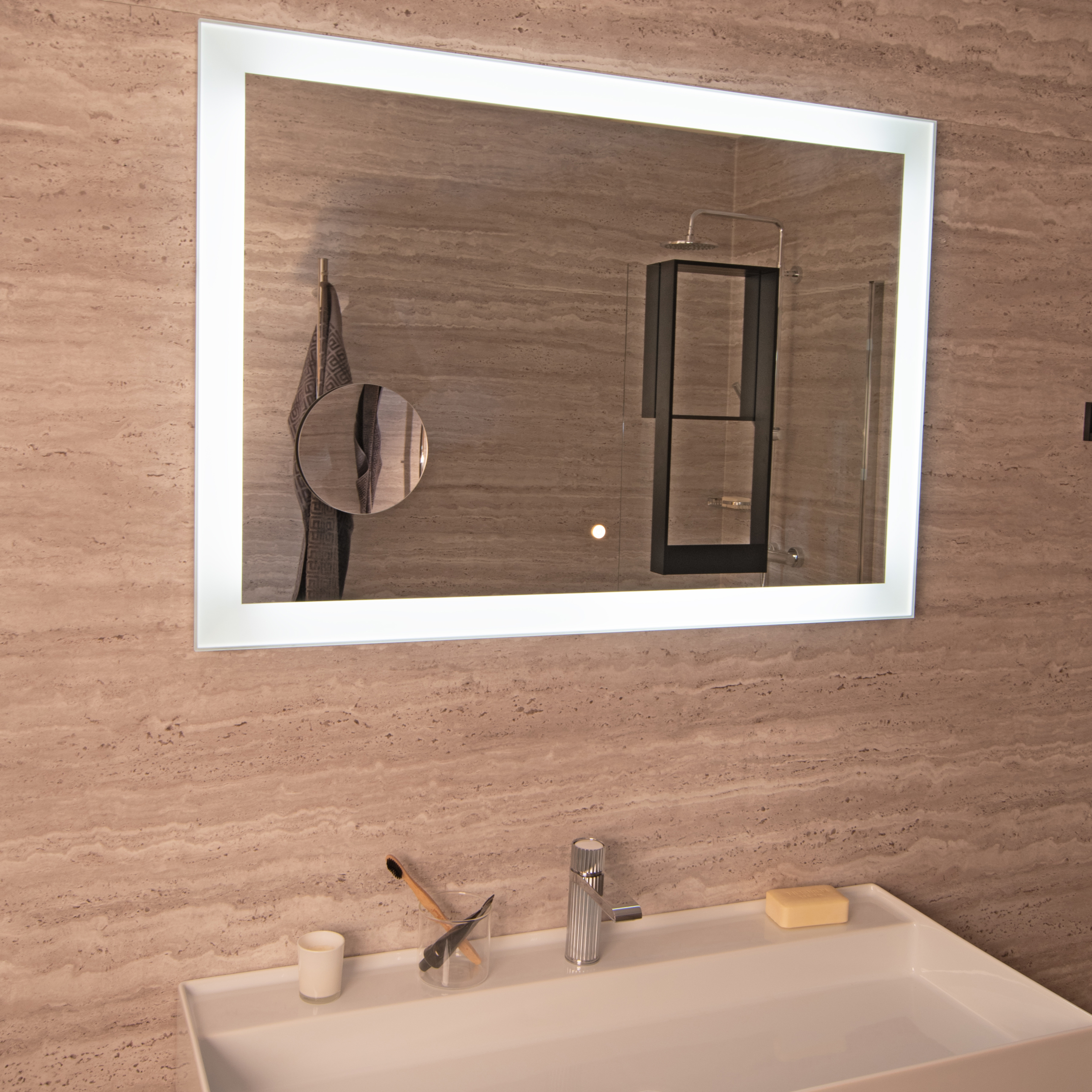 Limbar sminkspegel som sitter på en spegel i ett badrum.