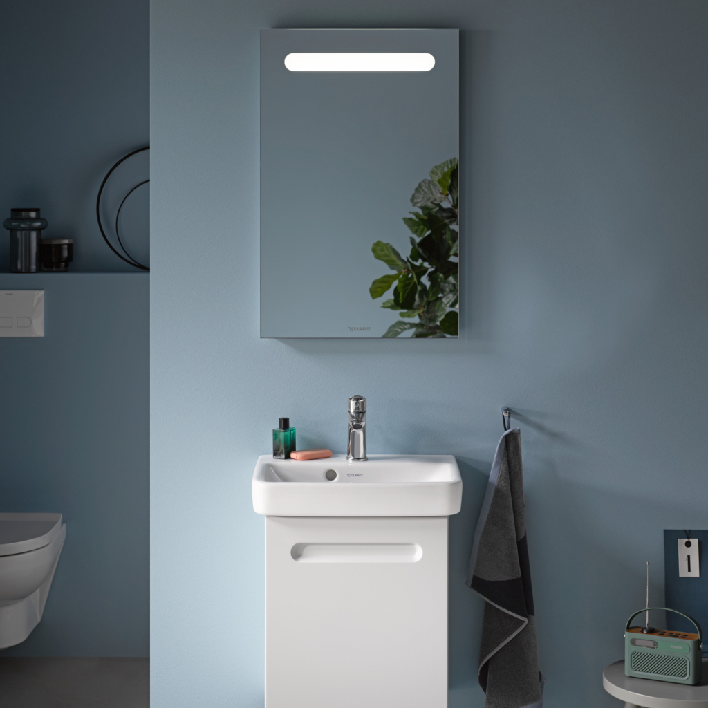 Kommod, högskåp och spegelskåp med belysning i ovankant från serien No.1 från Duravit i färgen vit. Sittandes på en blå vägg.