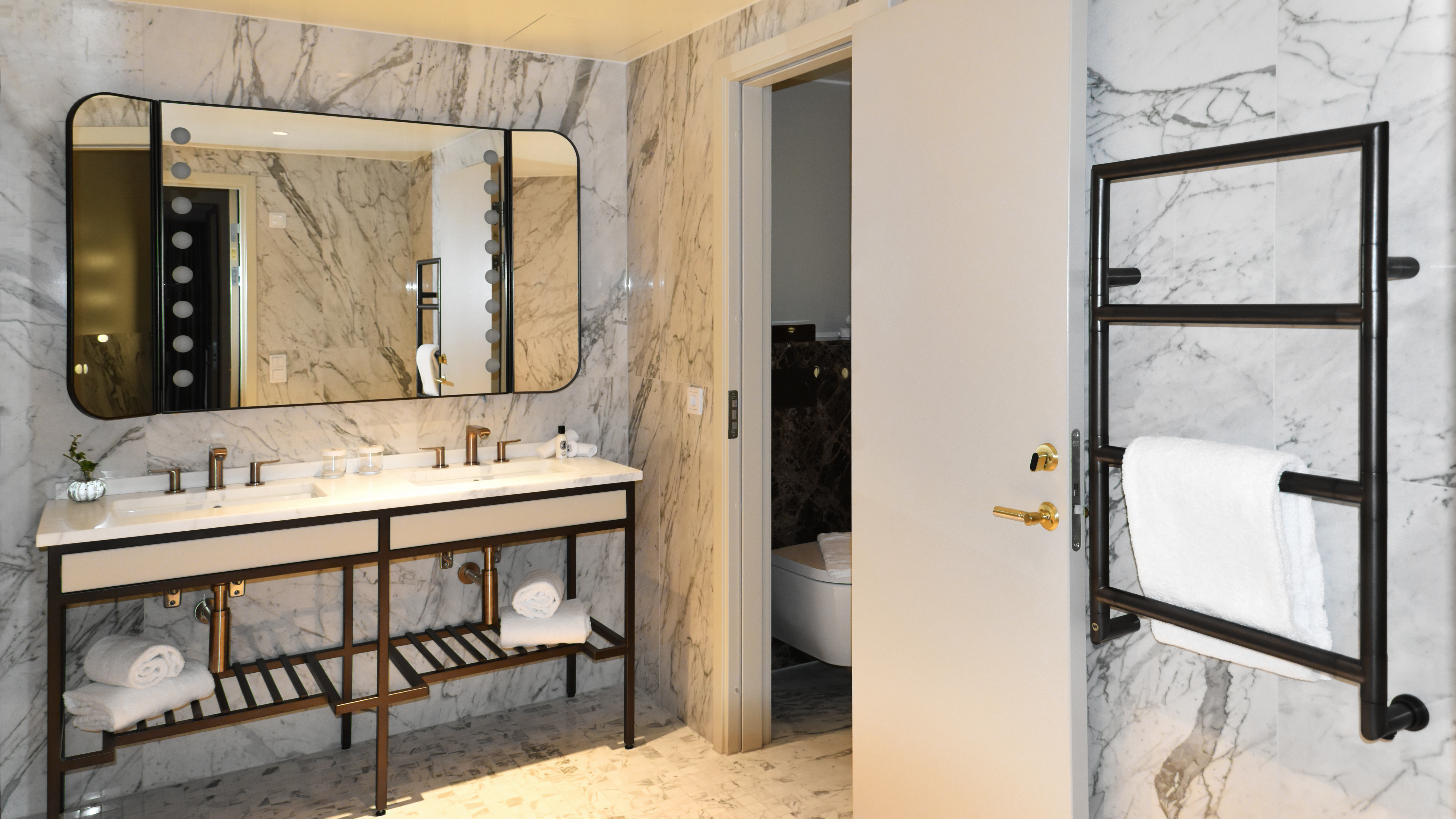 Badrum med en stor spegel. dubbeltvättställ och en handdukstorken  Parma.
