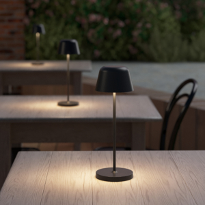 Nomad bordslampa på ett träbord.