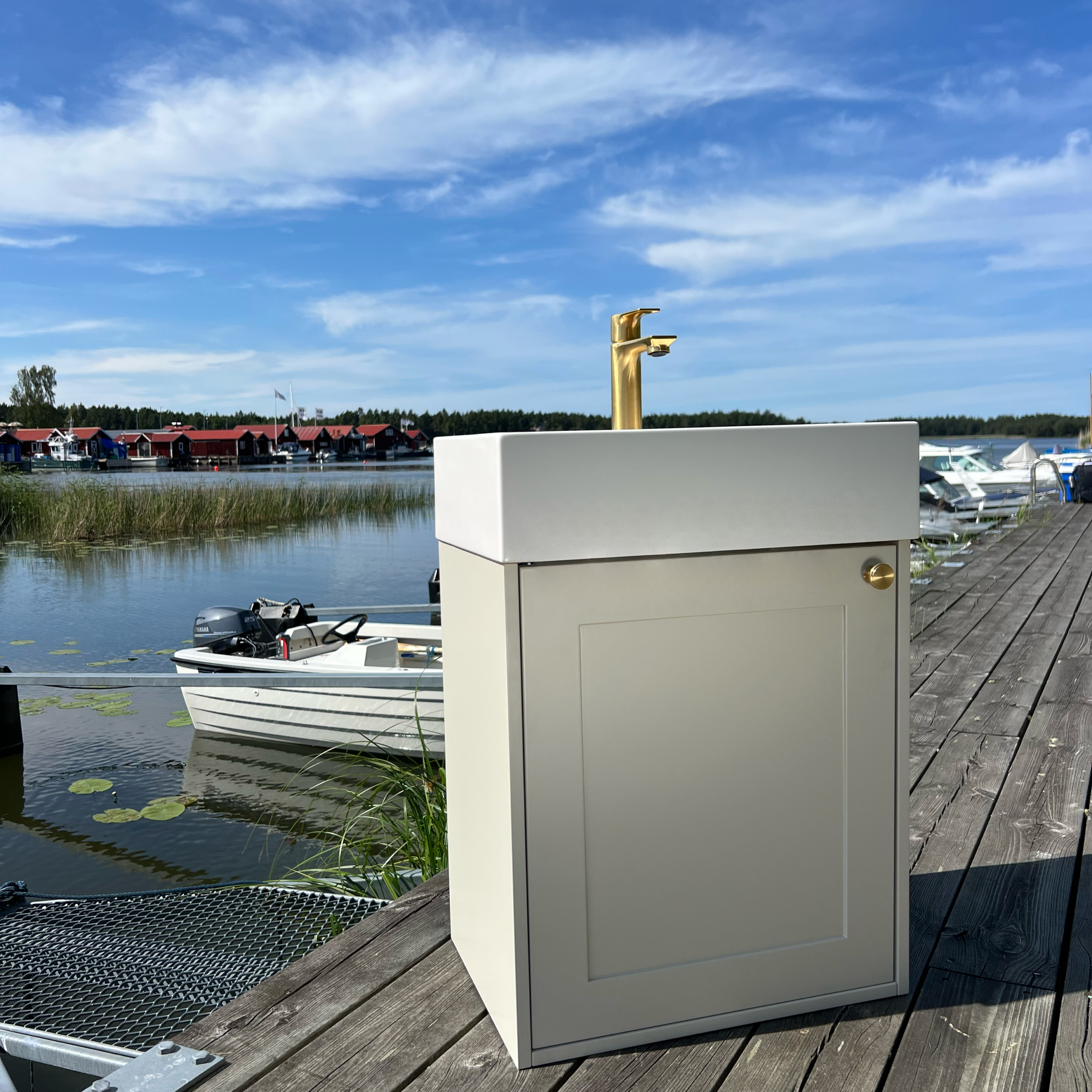 Spiken 485 tvättställsskåp med tvättställ och blandare å en brygga.