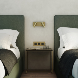 Enna Twin sänglampa, läslampa på en vägg mellan två sängar, ovanför ett sängbord.