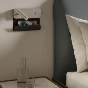 Enna Surface USB läslampa för vägg med hylla för mobil bredvid en säng.