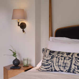 Club Reader, läslampa med skärm på en vägg vid en säng.