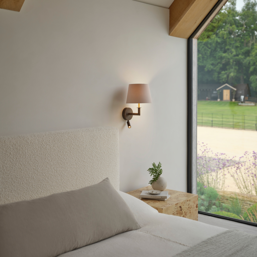 Club Reader, läslampa med skärm på en vägg vid en säng.