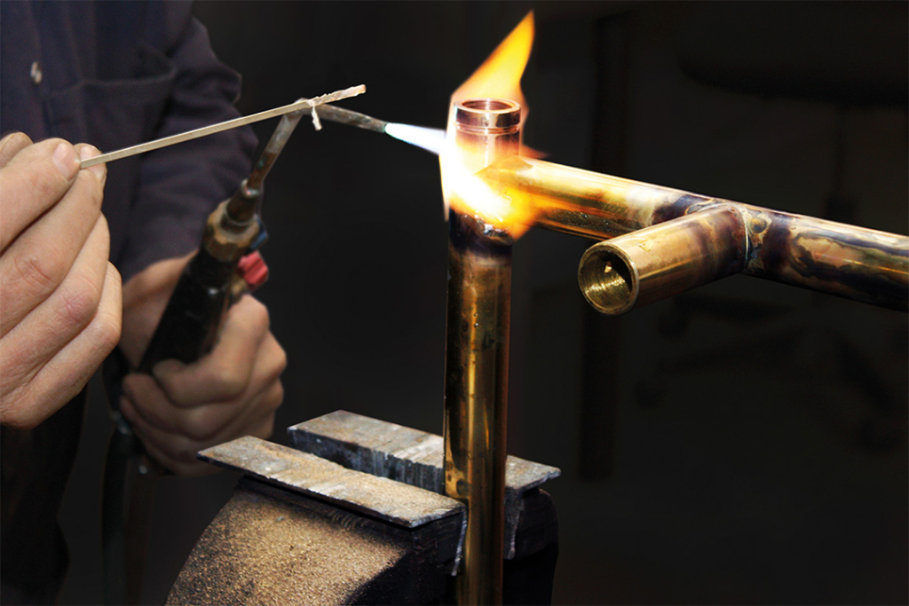 Lödning av handdukstork där lågan från elden syns