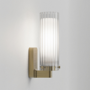 Elegant vägglampa i matt borstad mässing med glaskupa
